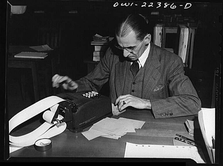 Old black and white film photo of a man using a 10-key